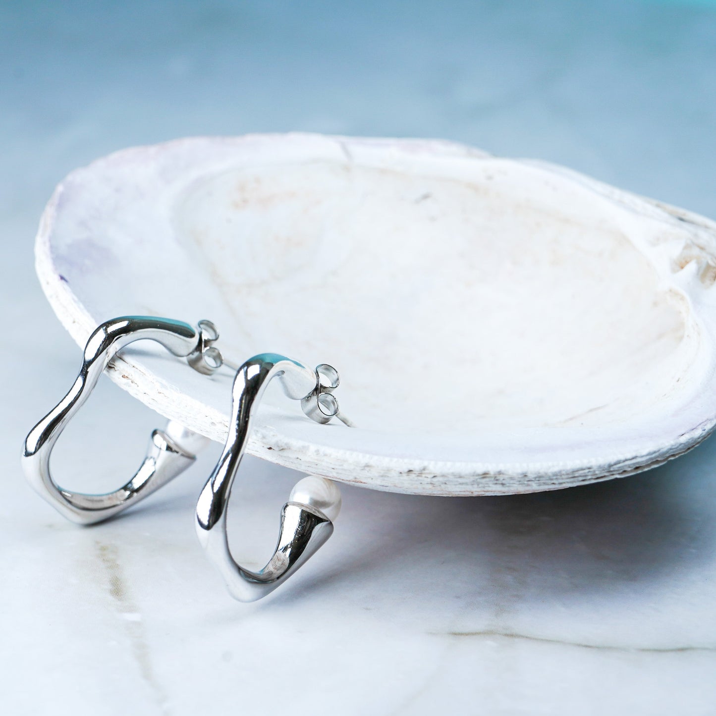 Wavy silver hoop earrings with pearl accent