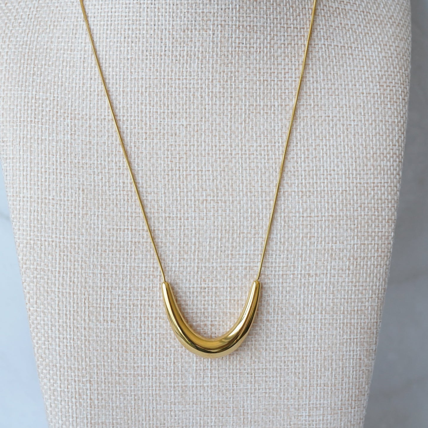 Gold curve pendant necklace